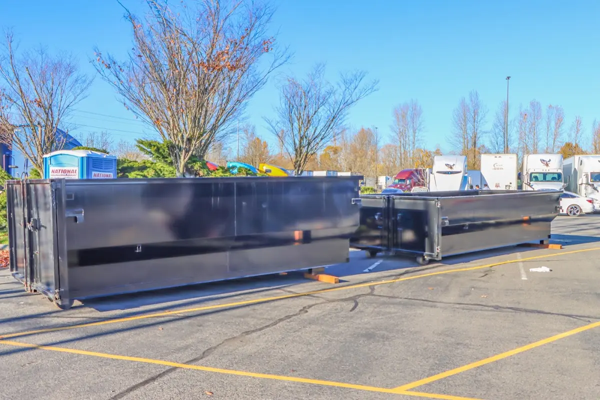 Professional dumpster rental service with roll-off container on residential driveway in D'Iberville